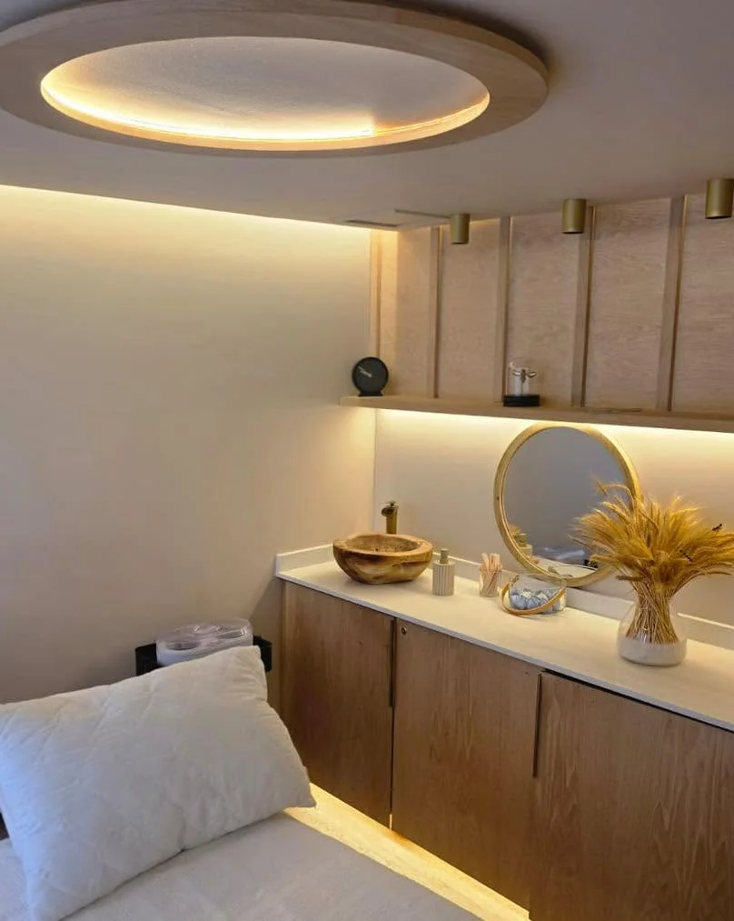 Treatment room at Skulpt with a brass ceiling light, marble vanity and warm neutral tones