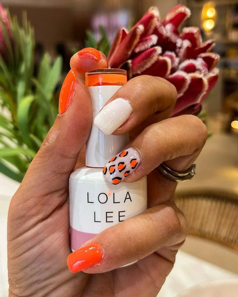 Vibrant nail art with a protea backdrop at the Skulpt Nail Bar